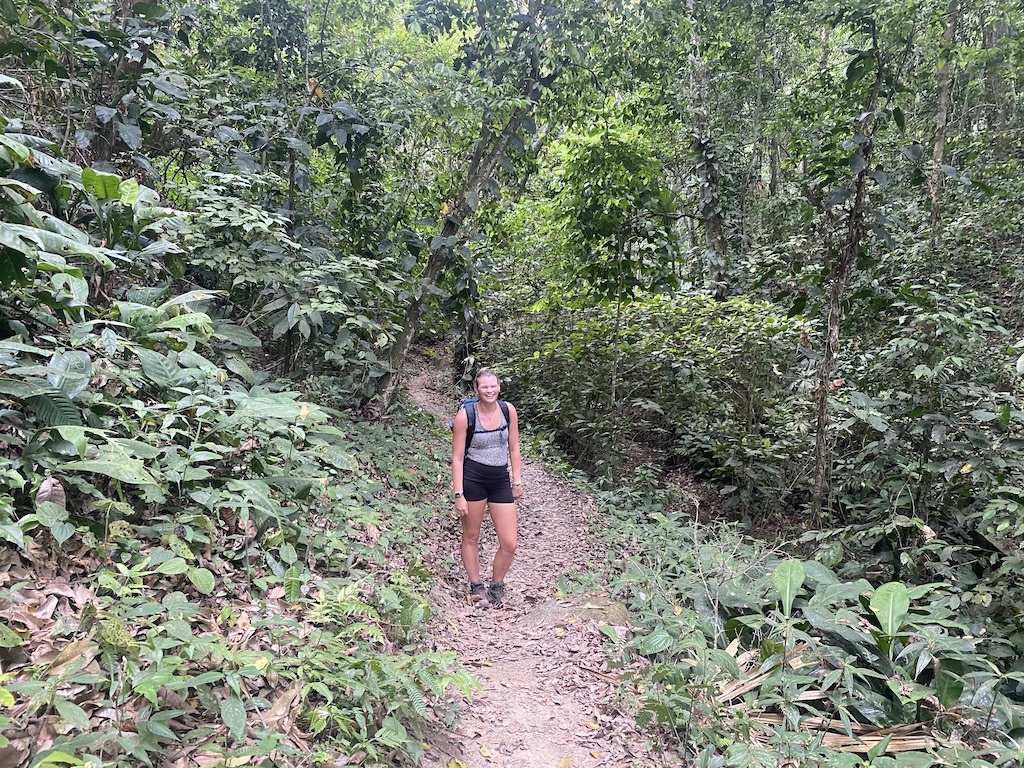 Lou standing on the trail through the park, surrounded by forest
